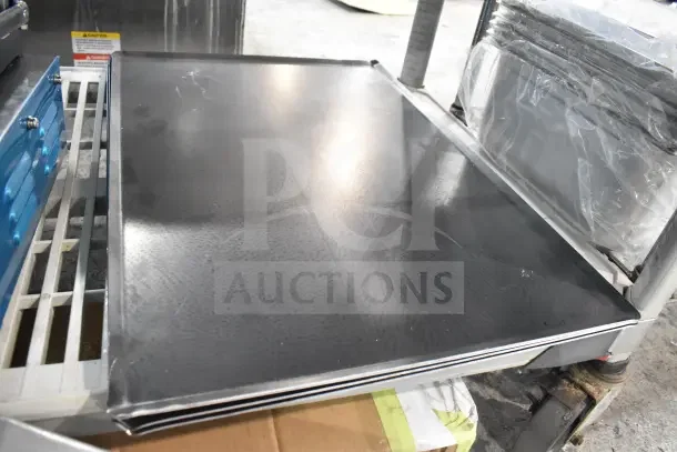 Nine brand new kitchenware pieces including a Chicago Metallic jumbo muffin pan, Choice pizza pan, and Matfer Bourgeat sheet pan.