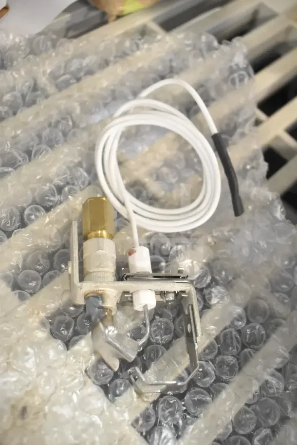 Brand new Vulcan 00-856615-00001 pilot burner on bubble wrap. Includes components and wiring.