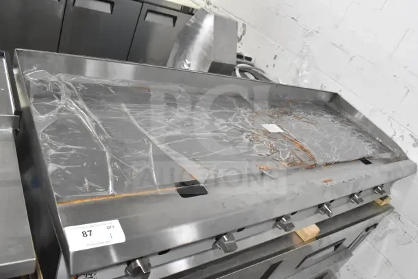 Brand new Cooking Performance Group GM-CPG-72-NL 72" gas griddle with manual controls, 180,000 BTU, covered in protective film.