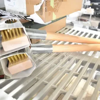 2 new Malish UGB Ultimate Grill Brushes, scratch and dent, with wooden handles and brass bristles, on a shelf.