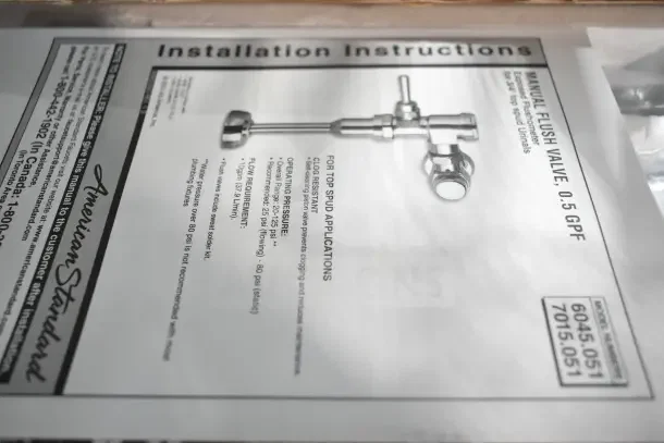 New American Standard 6045051.002 Ultima urinal flush valve, manual piston, 0.5 GPF, model number visible in installation guide.