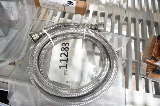 2 brand new Hobart 00-293408 stainless steel flex hose, coiled with connectors, on a shelf. Item tag reads 11283.