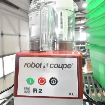 Brand new Robot Coupe R2BCLR food processor, 3 qt clear bowl, 120V, slight scratches, auction lot tag visible.