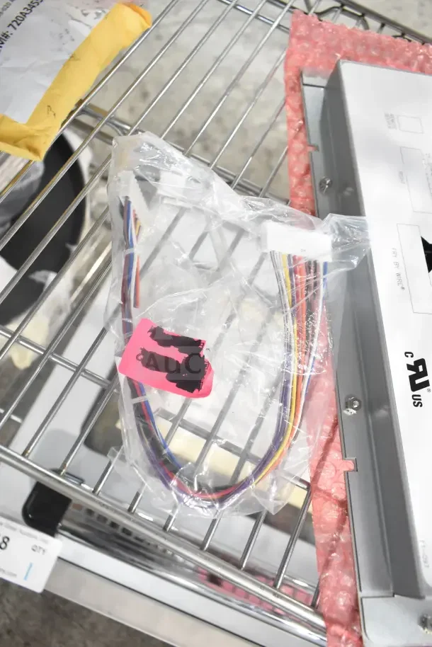 Brand new Scotsman A34559-020 auger bearing, visible wiring, and Pitco computer with harness in packaging on metal rack.