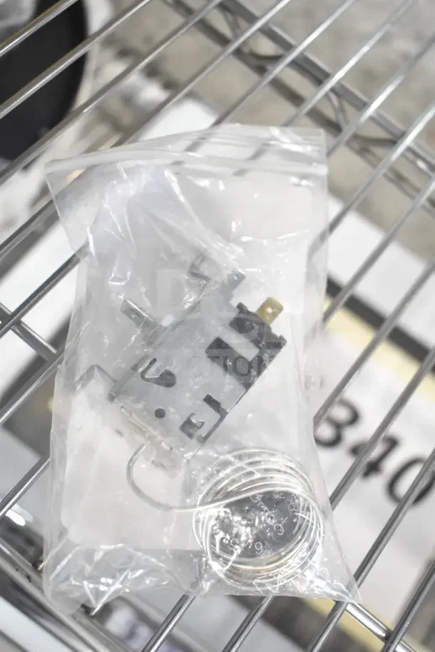 Brand new True 800384 Temperature Control Kit with Dial in clear plastic packaging, on a metal rack.
