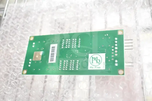 Green electronic circuit board, Pb-Free labeled, on bubble wrap. Includes various new parts like Scotsman auger bearing and Pitco computer.