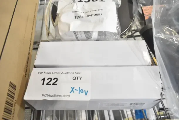 10 new scratch and dent items in packaging, including Lavex UV bulb and Southbend timer. Auction tag labeled 122.
