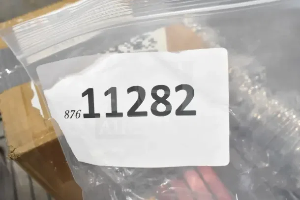 Bag labeled "11282" containing assorted scratch and dent items, including label holders, casters, and metal buckets.