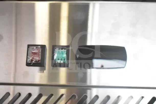 Close-up of controls on Avantco 178Z2RGHC Commercial Cooler, featuring red and green switches on a stainless steel panel.