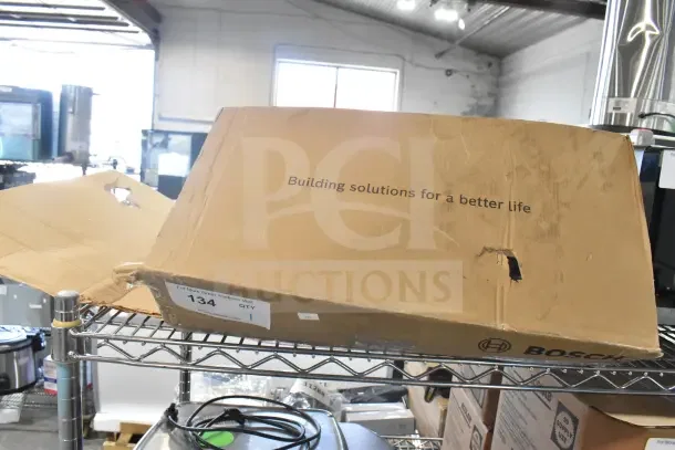 Brown cardboard box labeled "Building solutions for a better life," containing Bosch PRA-AD608 8 Channel Amplifier. Box is slightly worn.