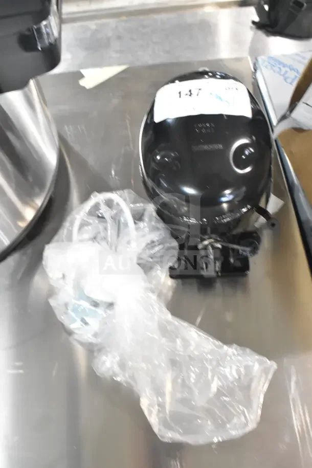 Brand new Cubigel NUT70NR Avantco 17817638 compressor, scratch and dent condition, black, includes attached tubing and markings.
