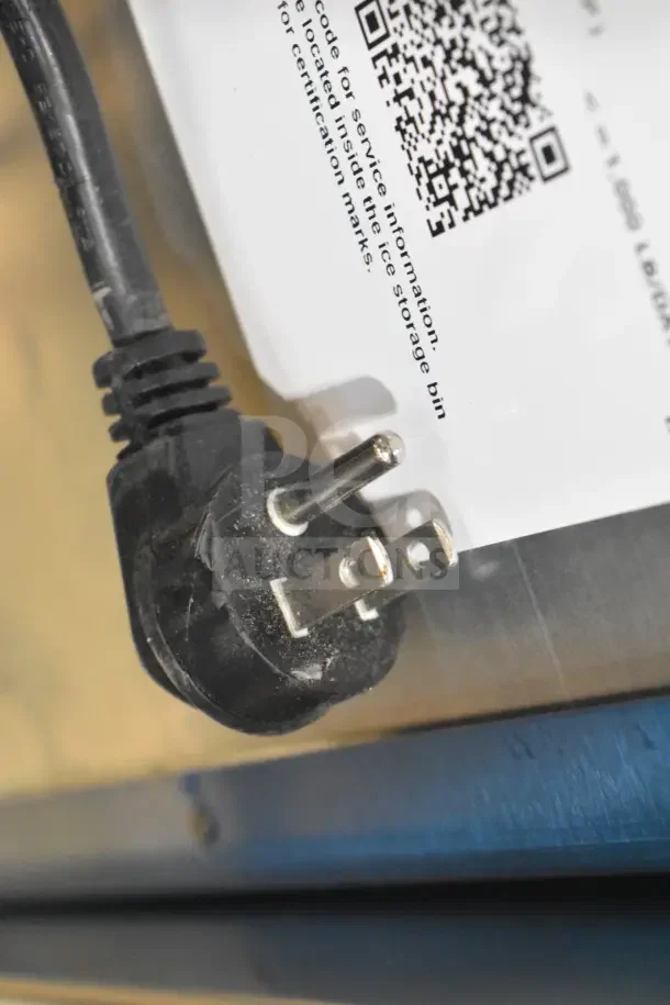Close-up of a power plug next to a QR code and text on a label, indicating service information for a Hoshizaki ice machine.