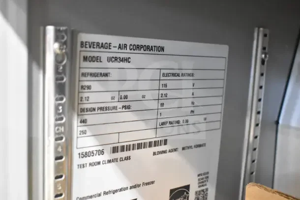 Beverage Air UCR34HC label showing refrigerant, electrical ratings, and design pressure details in a stainless-steel interior.