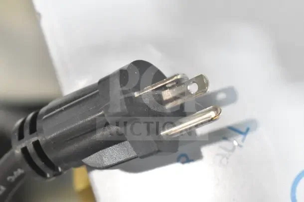 Close-up of a plug for the Waring WPG300 Panini Grill, showing the prongs and part of the black plastic body.