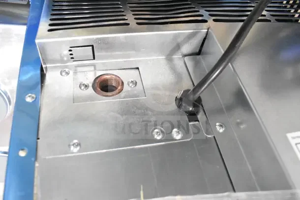 Brand new Hoshizaki AM-50BAK undercounter ice machine; interior view showing connection ports, cable, metal housing.