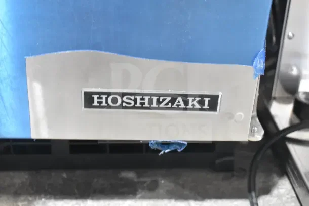 Brand new Hoshizaki AM-50BAK undercounter ice machine, 27 lb. bin, 54 lb. capacity, 115V, with visible scratch and dent.