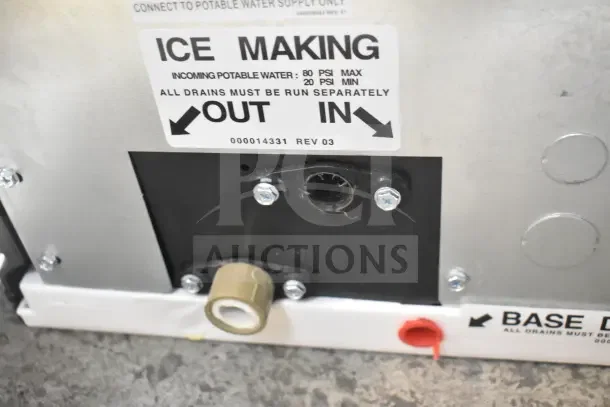 Close-up view of a Manitowoc IDP0450A-161 ice machine's connection panel, showing ice making instructions and drainage labels.
