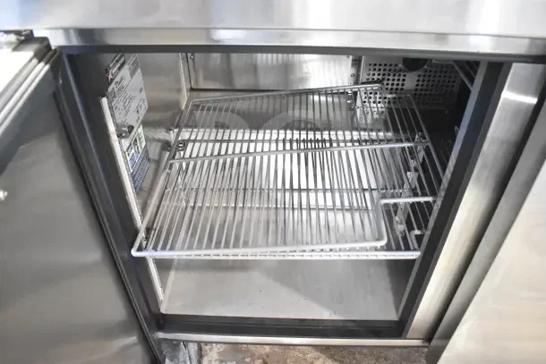 Brand new 2024 True TUC-48-HC undercounter cooler, commercial 2-door, 115V, with shelves and label visible. Industrial casters.