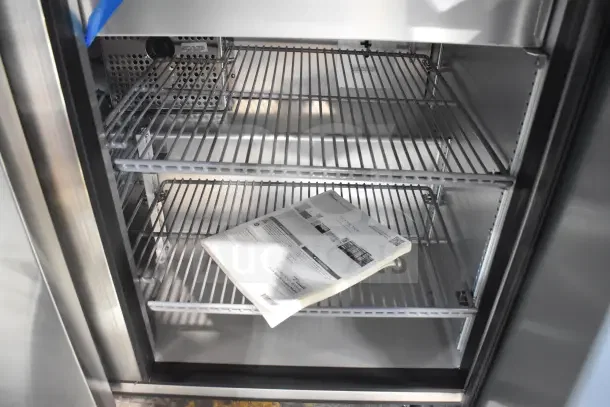 Brand new True TSSU-48-18MB-HC sandwich prep table interior, featuring wire shelves and instruction manual. Model TUC-48-HC.