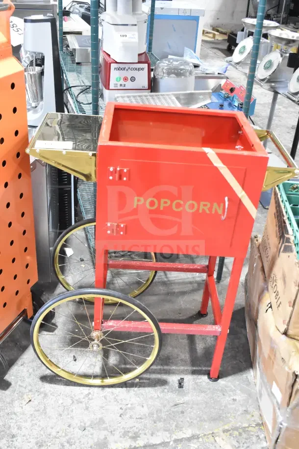 Red Carnival King popcorn cart with gold accents, large wheels, labeled "POPCORN," in scratch-and-dent condition.