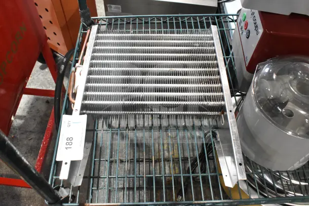 Brand new scratch and dent evaporator coil, metal fins, copper tubing, inventory tag 188, on storage rack.