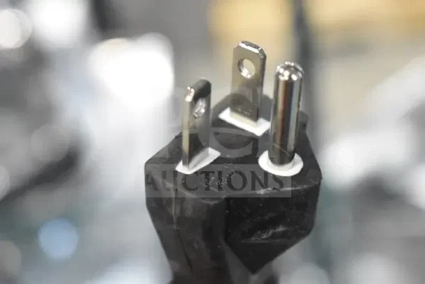 Close-up of a three-pronged power plug for the Avantco 177IC3500 induction range, showing metal prongs and black casing.