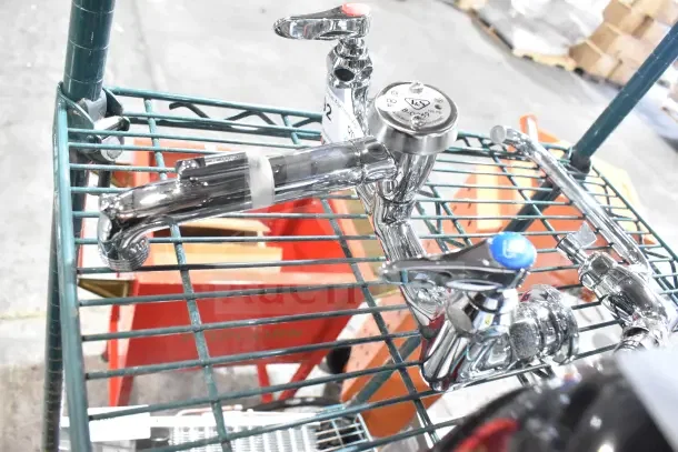 Two scratch and dent chrome faucets, brand new, displayed on a metal shelf. Tags indicate model details.