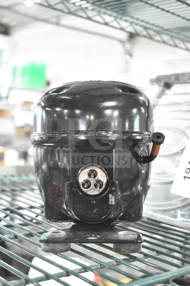 Brand new Cubigel NUT55NR Avantco 17813580 compressor, scratch and dent condition, on a metal shelf.