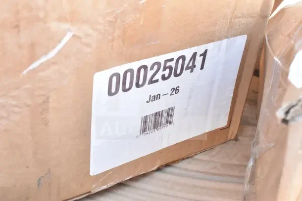 Cardboard box with label "00025041 Jan–26" and barcode, containing 15 new scratch and dent items for auction.