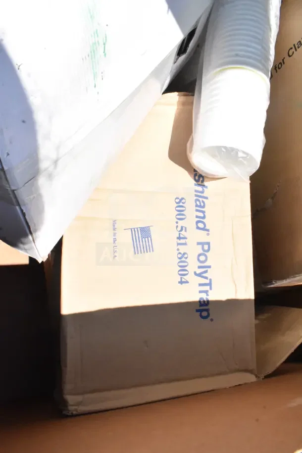 Cardboard box of Ashland PolyTrap grease trap, marked "Made in the USA," visible in scratch and dent auction lot.