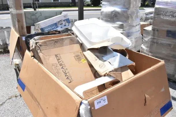 Cardboard box containing scratch and dent items including a Lancaster Table & Seating chair dolly, mop bucket. Various boxes visible.