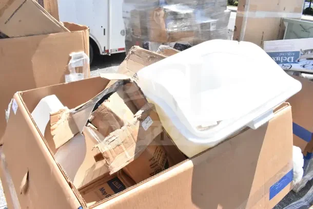 Seven brand new scratch and dent items including a chair dolly and mop bucket in open boxes. Some boxes show wear.