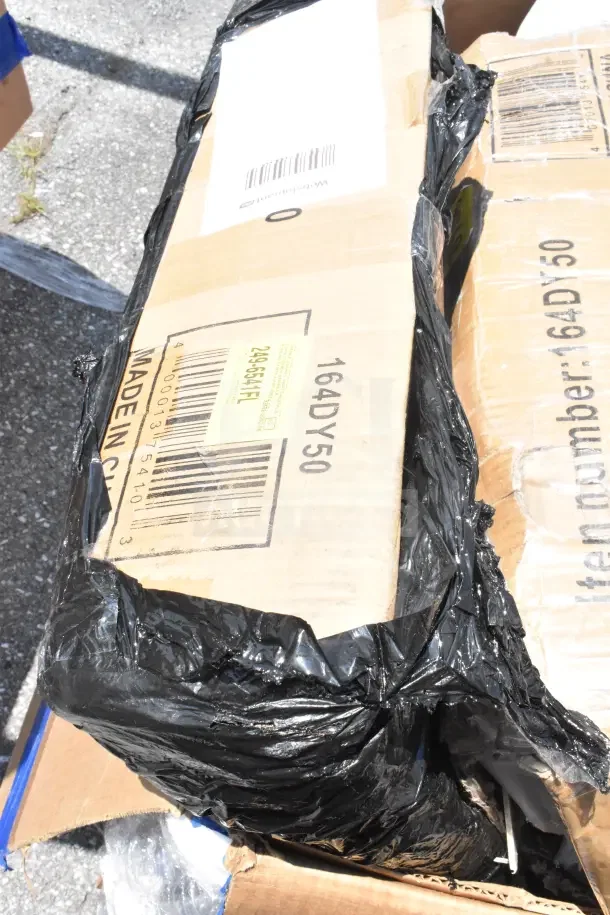 Cardboard box with black plastic wrap featuring barcode label "249-854F1." Listed as 7 new scratch and dent items, including a chair dolly and mop bucket.