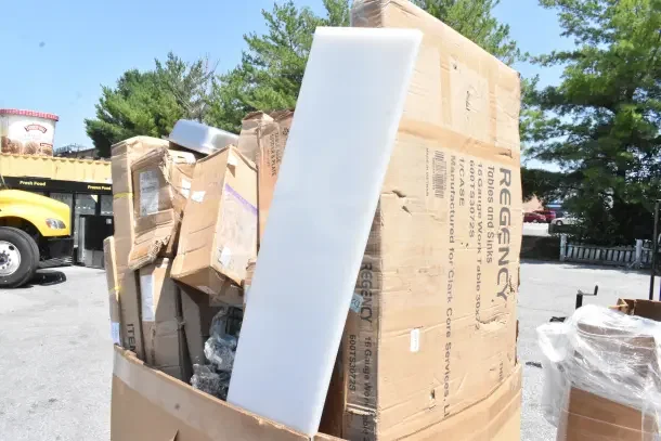 Large cardboard box containing 16 new scratch and dent items, including wall and wire shelves, pan rack. Regency label visible.
