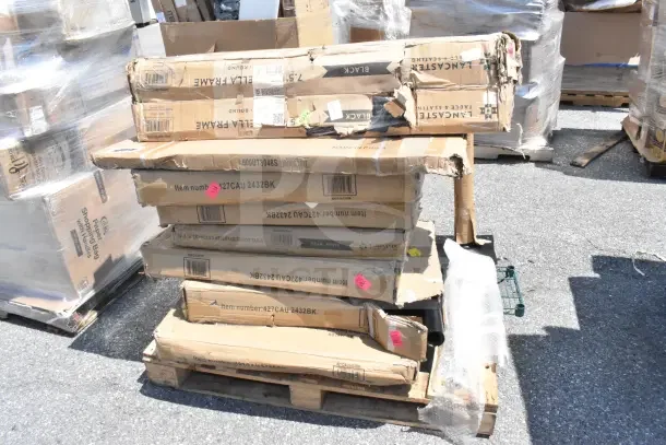 Stack of 13 new scratch and dent items in boxes on a pallet, including work and outdoor tables, labeled with model numbers.