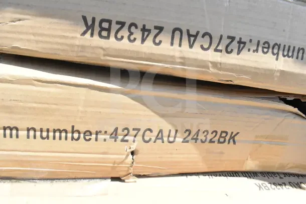 Cardboard boxes labeled with "Item number: 427CAU 2432BK," containing new scratch and dent items, including tables.