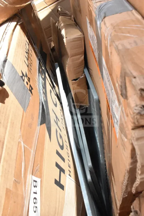 Cardboard boxes containing new scratch and dent items, including tabletops, sheet pan racks, and a high chair. Labels visible.