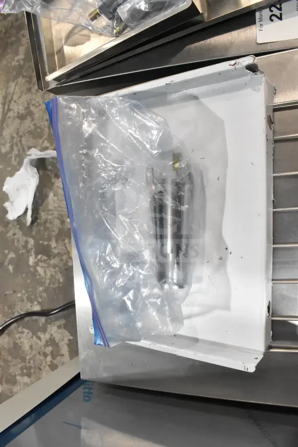 Clear bag containing metal component for Avantco 184T140 toaster, showing scratch and dent, in original packaging.