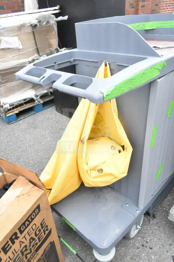 Brand new Lavex janitorial cart, scratch and dent condition, gray with yellow bag, tape accents, durable design.