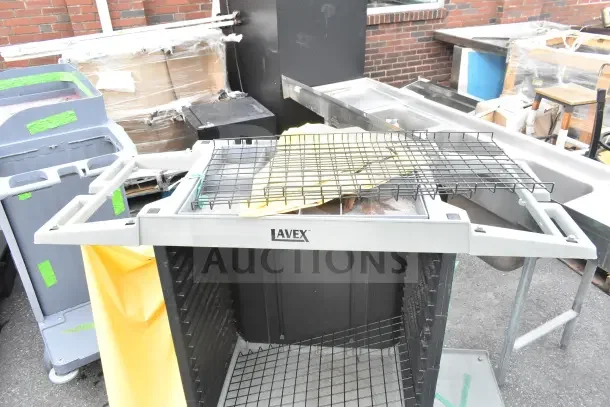 Brand new Lavex janitorial cart, visible wire racks, minor scratches, sturdy design, suitable for cleaning tasks.