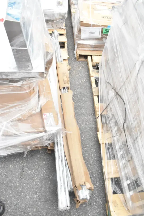 12 new scratch and dent items on pallets, including a wire shelf and evaporator coil, wrapped in packaging.