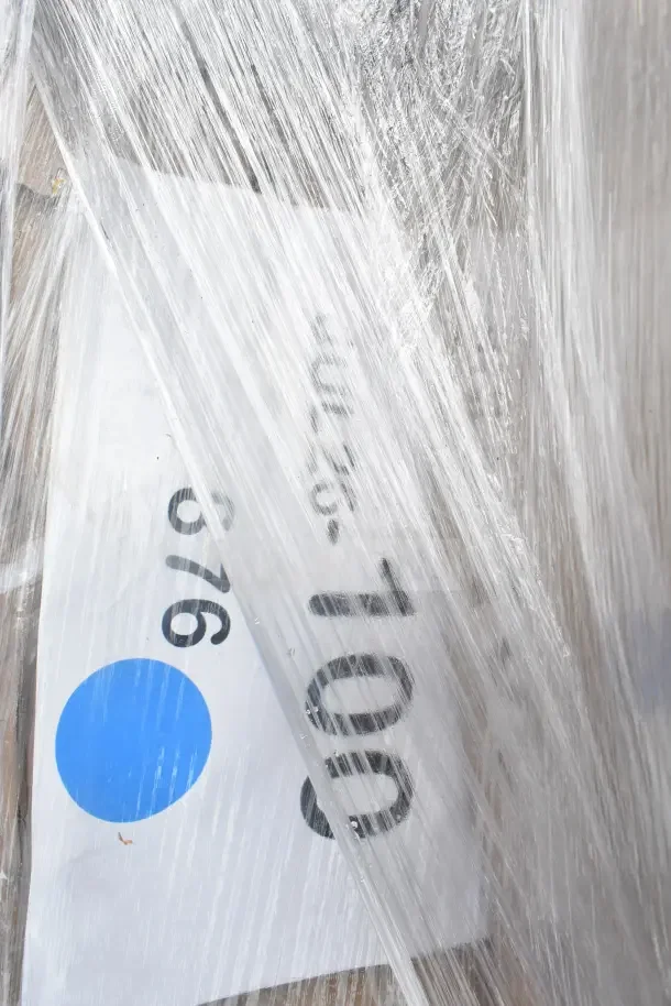 Plastic-wrapped lot of 12 brand new scratch and dent items, including wire shelf and evaporator coil. Labeled JUL26-100.
