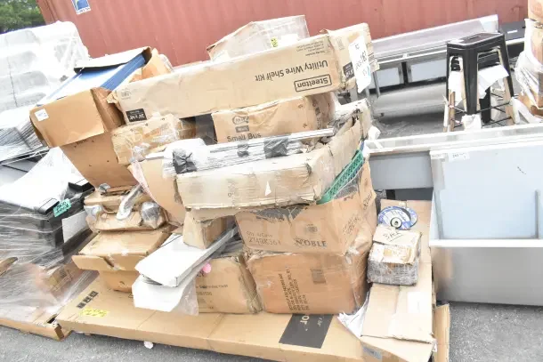 Pile of boxes containing 28 new scratch and dent items including grab bars and cheese grater. Mixed brands and visible box damage.