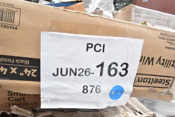 Cardboard box labeled "PCI" and "JUN26-163 876"; contains 28 new scratch and dent items, including grab bars and cheese grater.