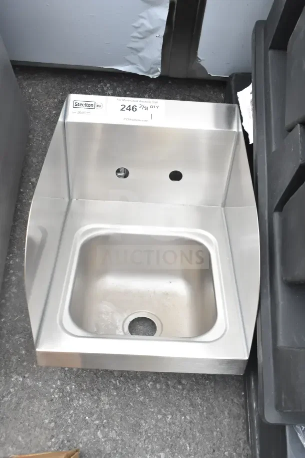 Brand new Steelton 522HS1216S 12"x16" wall-mount hand sink with side splashes, showing minor scratches. Label visible.