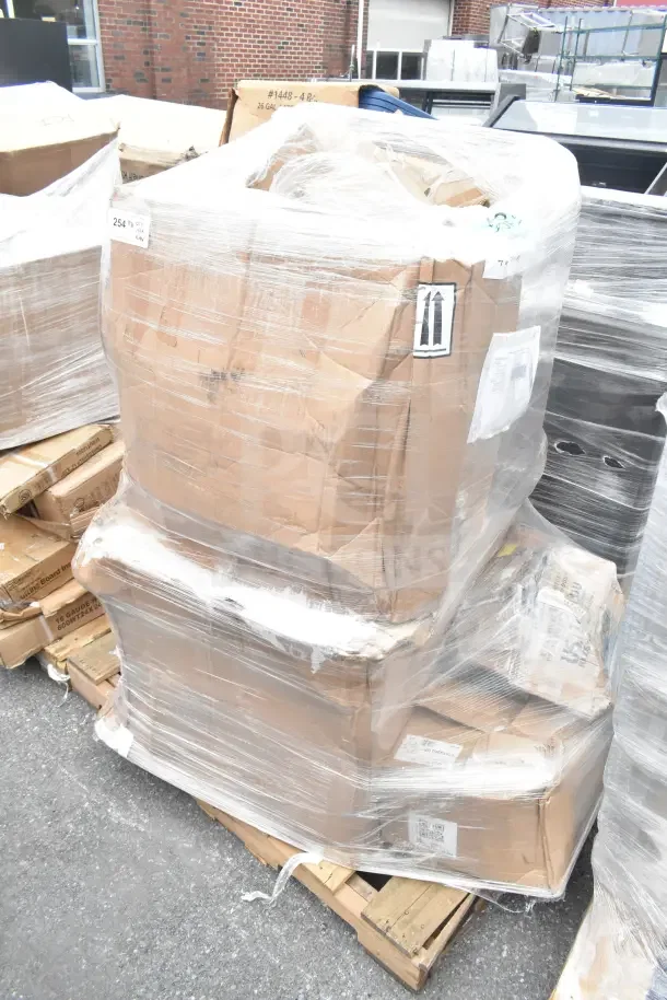 Pallet wrapped with cardboard boxes labeled "254," containing scratch and dent items including a pan rack and sink.