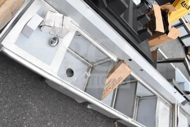 Brand new Steelton 522CS31818LR 90" commercial sink with three compartments, two 18" drainboards, minor scratches visible.