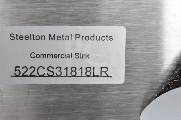 Steelton 522CS31818LR label on a stainless steel commercial sink surface, indicating model details.