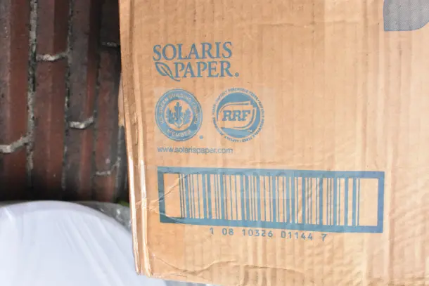 Cardboard box labeled "Solaris Paper" with eco-friendly certification markings, barcode, and a visible dent. Contains 14 new scratch and dent items, including sinks.