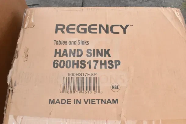 Cardboard box labeled "REGENCY Tables and Sinks, Hand Sink 600HS17HSP, Made in Vietnam." Box shows minor wear.
